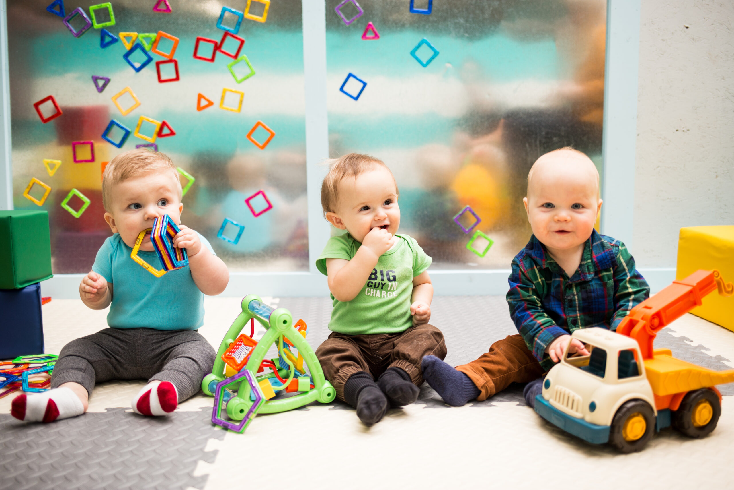 Three Babies Sitting Up and Playing with Toys
